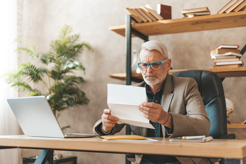 man looking concerned at paper in office