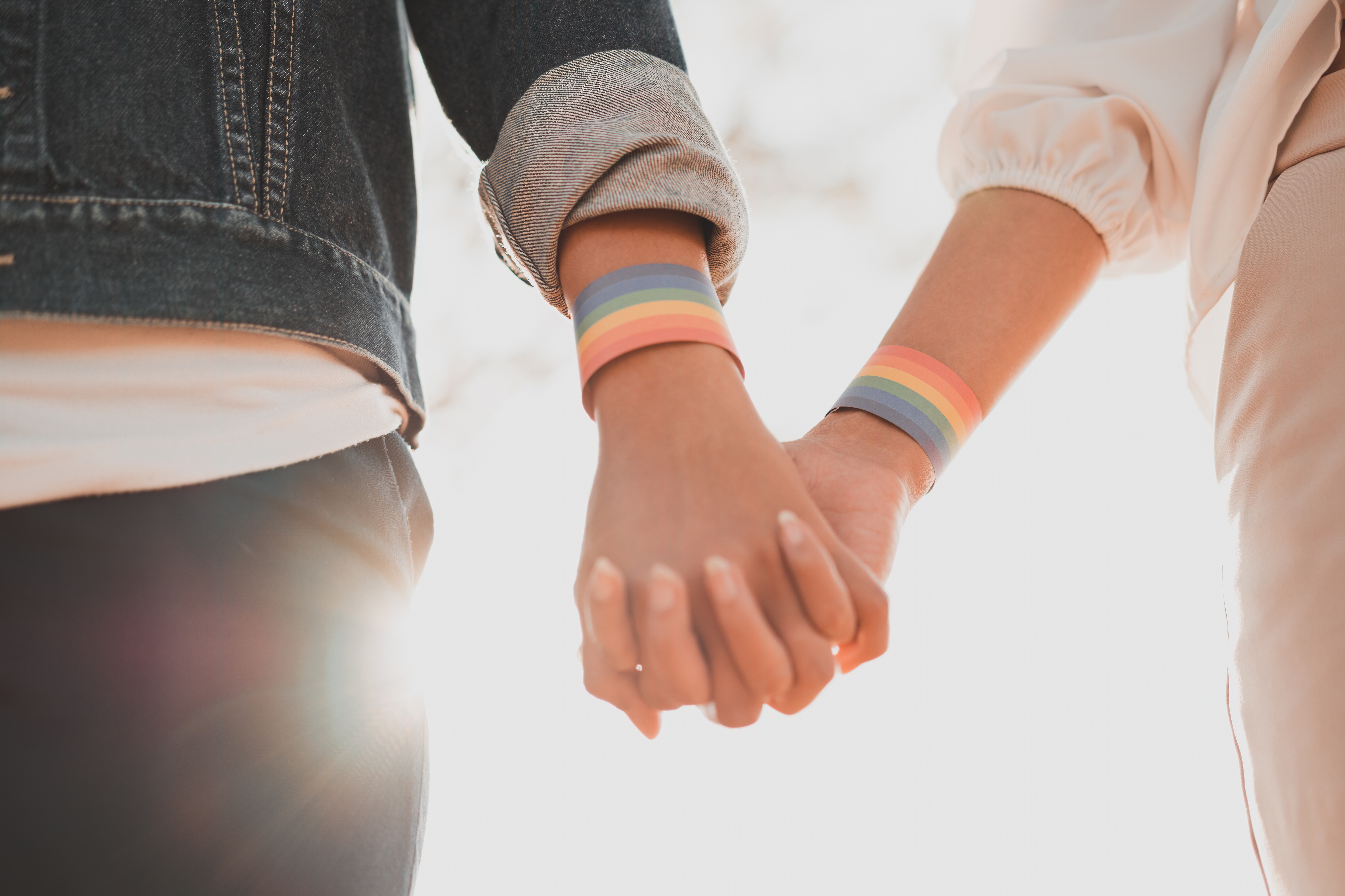 Holding hands with pride bracelets