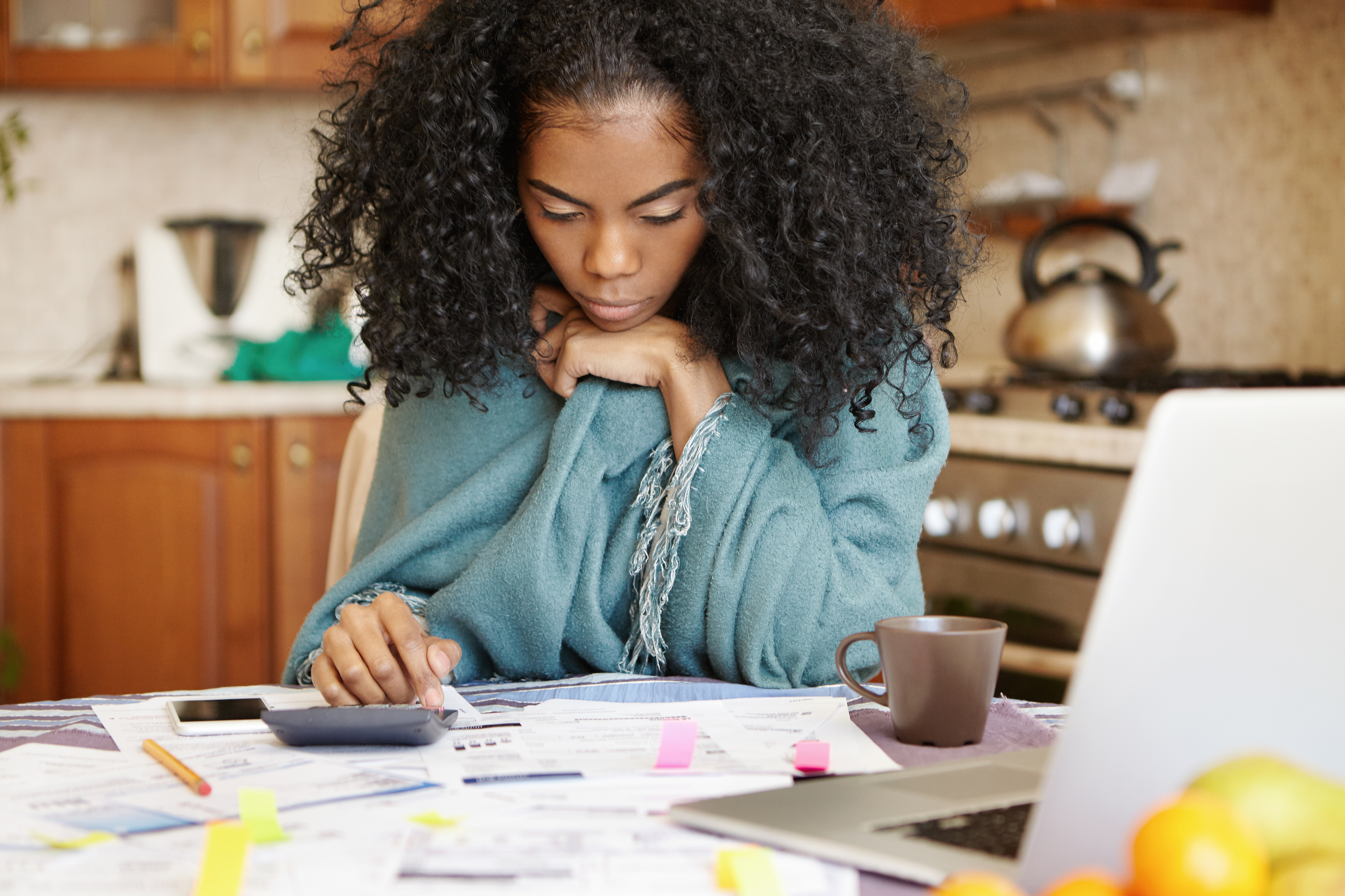 woman reviewing paperwork with calculator